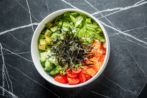 Colorful and fresh salad bowl featuring crisp greens and vibrant vegetables on a dark marble surface