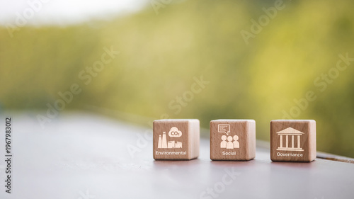 Wooden blocks with ESG icons Environmental Social and Governance on natural green background.