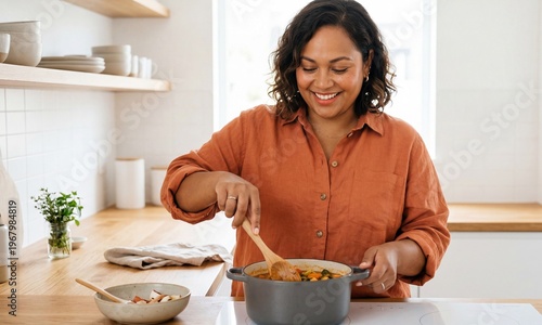 Plus size woman cooking alone and smiling in modern kitchen  