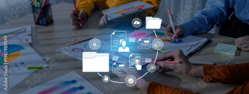 Fotografi A group of people collaborates on business documents and charts at a modern office table, with digital icons representing data management and teamwork concepts