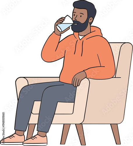 A man sits on a chair drinking from a glass in a relaxed environment
