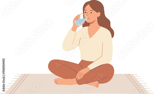 Woman sits cross-legged on a rug drinking from a glass.