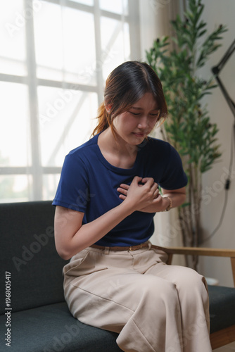 Young woman experiencing chest pain holding her chest
