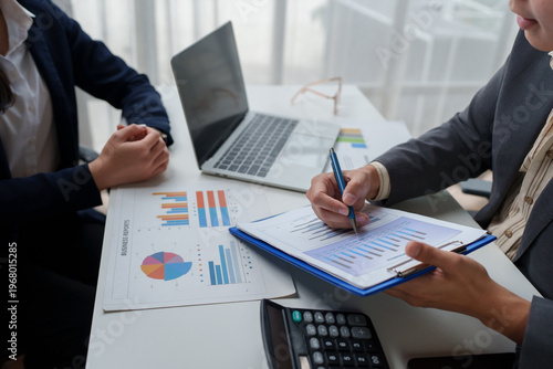 Business people analysing data, collaborating on reports