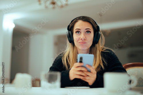 Tableau sur toile Puzzled Woman Wearing Headphones Checking her Phone