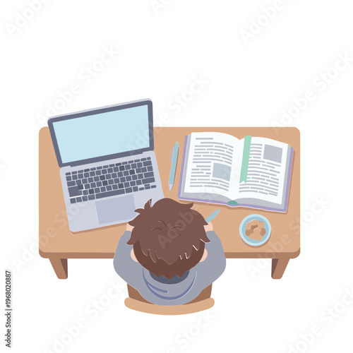 A person sits at a desk studying with a laptop and book