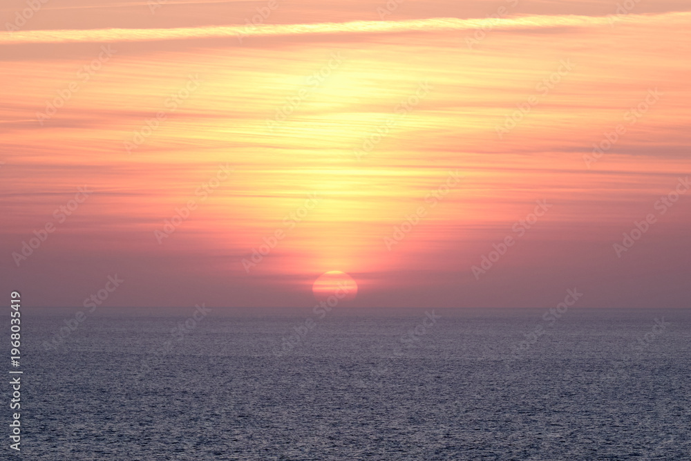 Fototapeta premium Golden Sunset Over Atlantic Ocean in Algarve Portugal with Calm Sea Horizon