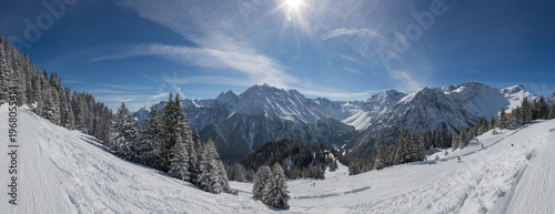 European Alps at skiing area Brandnertal, snowy mountains with blue sky (panorama)