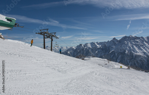Chairlift at European Alps at skiing area Brandnertal, snowy mountains with blue sky