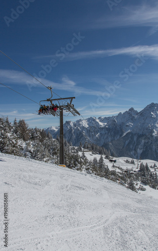 Chairlift at European Alps at skiing area Brandnertal, snowy mountains with blue sky