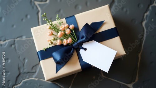 Elegant gift box with flowers and a tag on a textured surface