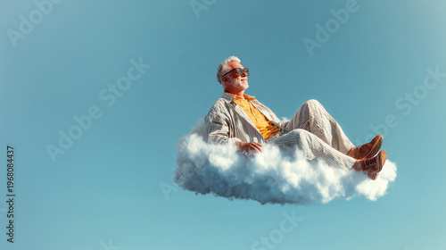 Stylish senior man relaxing on a fluffy cloud against blue sky background symbolizing retirement, freedom, peace of mind and carefree lifestyle
