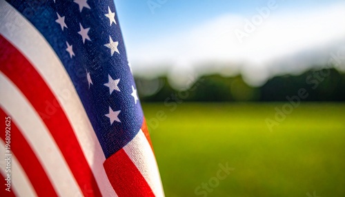 Ultra-detailed macro footage of the United States flag stretched across a field, wind gently moving the fabric, blue sky above, bokeh effect