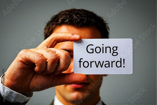 Man holding a card with the text Going forward!
