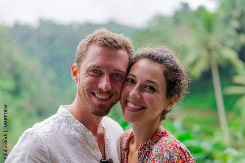 Obraz premium Close-up portrait of happy honeymoon couple embracing with lush bali jungle background, natural daylight, soft green bokeh, warm genuine smiles modern setting
