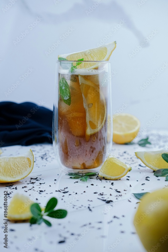 Fototapeta premium Refreshing iced tea with lemon slices and fresh mint on marble surface for summer healthy lifestyle advertising food blog and organic.