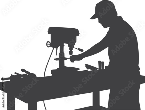 Silhouette of a man using a drill press