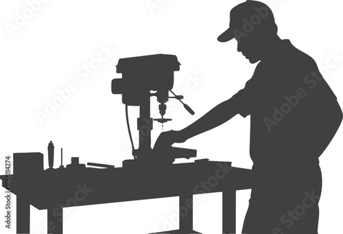 Silhouette of a man using a drill press