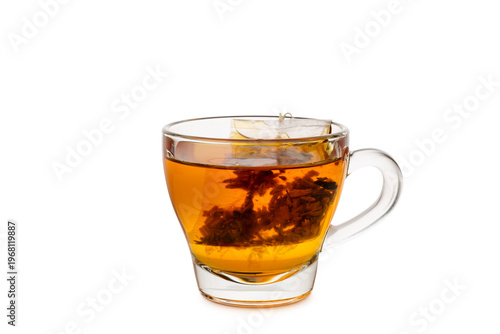 Glass cup of tea with tea bag inside, isolated on white background.