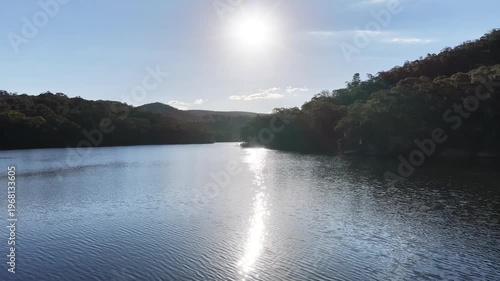 Drone across lake sun on water