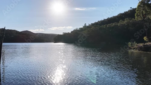 Drone across lake sun on water