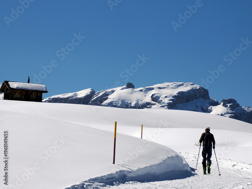 trekker near wooden hut covered by snow in armentarola pralongi? dolomites mountains