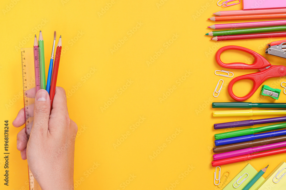 Fototapeta premium Hand holding pencils and ruler with school supplies