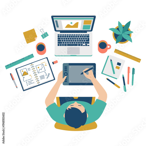 A person sits at a desk working on a laptop and graphics tablet surrounded by office supplies.