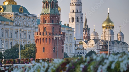 Moscow Kremlin architecture and cathedrals under clear sky with flowers in foreground