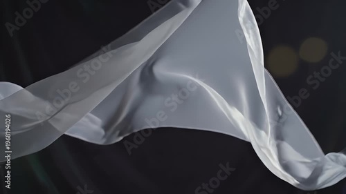 Soft white fabric waves in dim light with blurred golden orbs in background