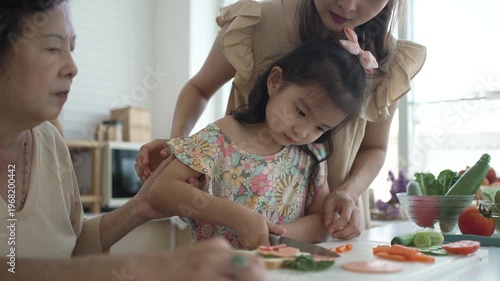 Daughter, mother and grandmother are preparing food together in the kitchen. Relationship, family, domestic life.