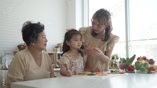 Daughter, mother and grandmother are preparing food together in the kitchen. Relationship, family, domestic life.