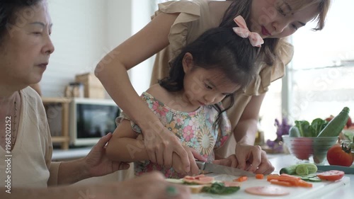 Daughter, mother and grandmother are preparing food together in the kitchen. Relationship, family, domestic life.
