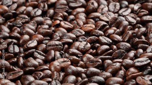 Close up rotating macro background of dark roasted coffee beans. Premium glossy texture for cinematic cafe and barista projects.
