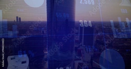 Framing cylindrical glass skyscraper rising above downtown at dusk, with HUD chart overlays
