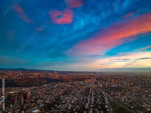 Cityscape at dusk with vibrant, colorful clouds above