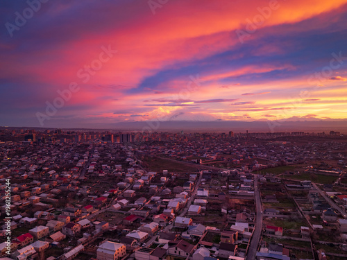 Sky paints city with hues of pink, orange, and purple at dusk