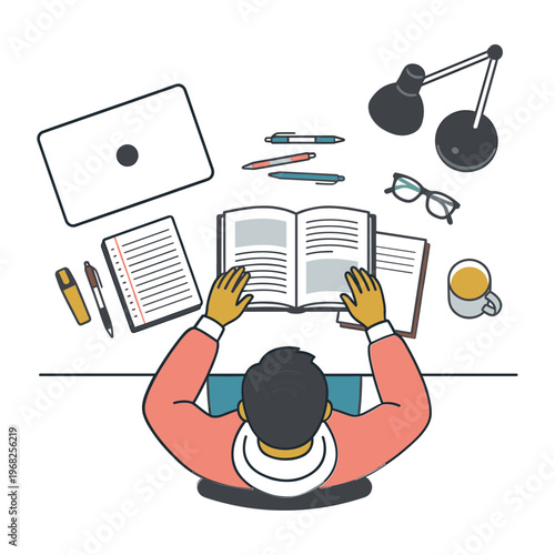 A person studies intently at a desk with books and a laptop nearby indoors.