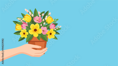 Human hand holding a terracotta pot filled with a vibrant bouquet of yellow and pink spring flowers on a blue backdrop.