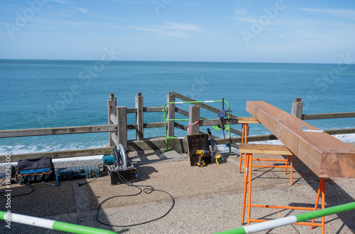 Obraz na plátne Construction work on seaside promenade with wooden beam tools and safety barrier