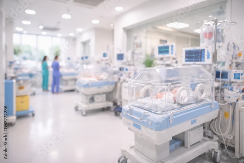 Newborn babies in incubators in a hospital neonatal intensive care unit (NICU) with blurred medical staff.