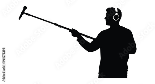 A musician with a boom microphone and headphones a striking silhouette