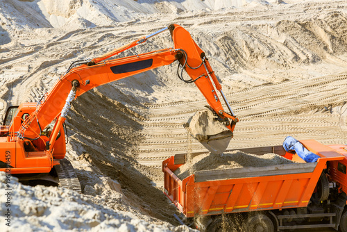 Work of the excavator and truck at a sand quarry.