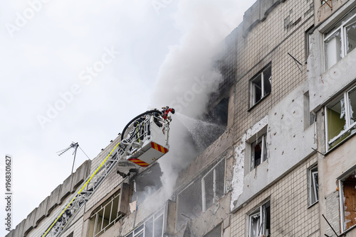 Firefighter on crane extinguishes fire with water from a hose. Boom crane with firefighters at a height of more than 30 meters.