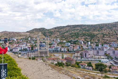 Turkey. Panoramic view of a large mosque with multiple minarets and a smaller dome structure, surrounded by residential buildings and hills in a Turkish city landscape
