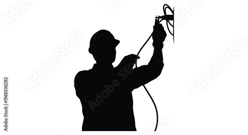 Lineman working with electrical equipment against a bright background silhouette