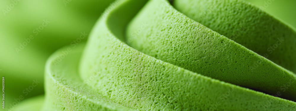 Obraz premium Green matcha whipped cream texture with soft swirls. Sweet dairy dessert topping pattern