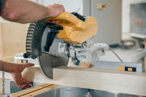 Foto Worker cuts a wooden beam circular saw.