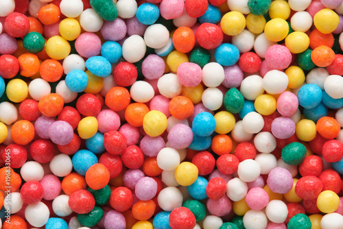 Macro photograph bright sugar sphere sprinkles, highlighting vivid colors and rounded shapes used for cake and cookie decorating.