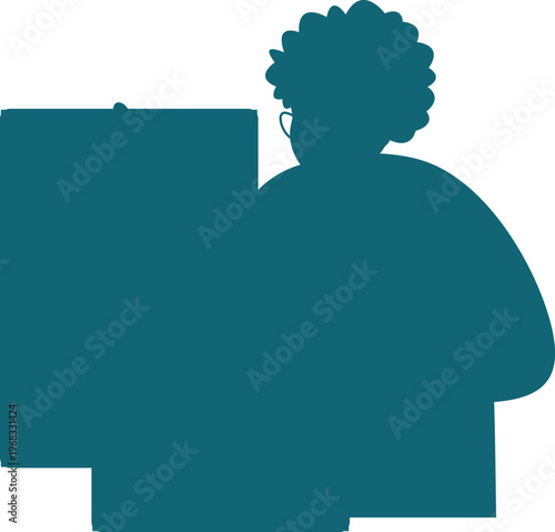 Person sitting at desk with headphones on and curly hair looking at a computer screen